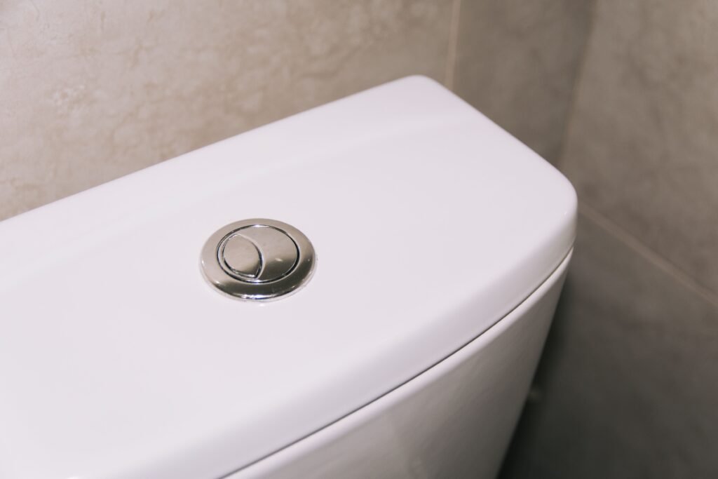 white plastic toilet flush tank with dual flush buttons